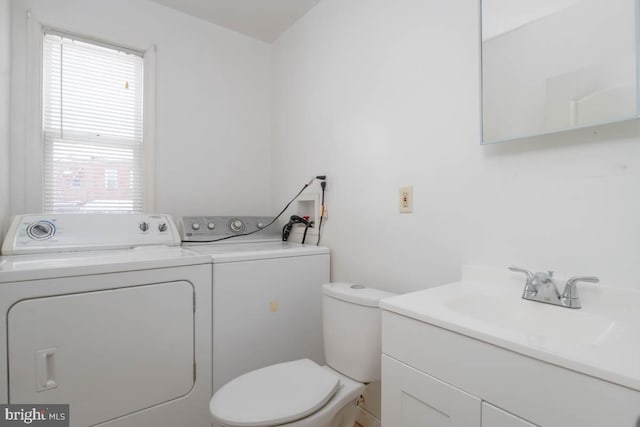 bathroom featuring vanity, toilet, and washing machine and clothes dryer