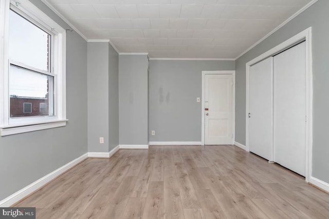 unfurnished bedroom with crown molding, light hardwood / wood-style floors, and a closet