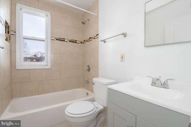 full bathroom with tiled shower / bath, vanity, and toilet