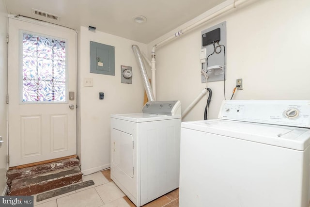 laundry area featuring separate washer and dryer, light tile patterned floors, and electric panel