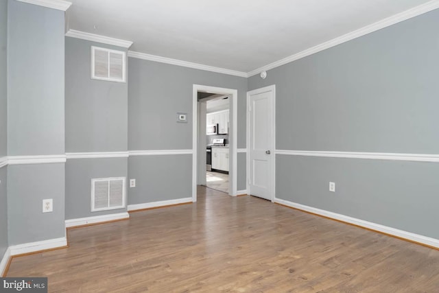 spare room featuring ornamental molding and light wood-type flooring