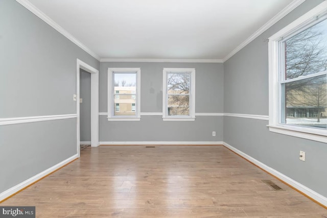 empty room featuring crown molding and light hardwood / wood-style flooring