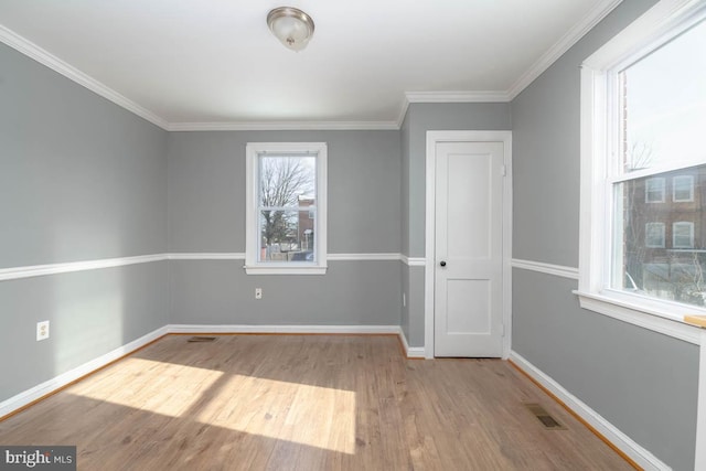 empty room featuring ornamental molding and light hardwood / wood-style floors