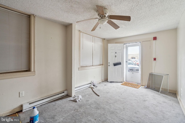 interior space featuring light carpet, a textured ceiling, ceiling fan, and a baseboard heating unit