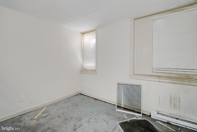 empty room featuring a textured ceiling and a baseboard radiator