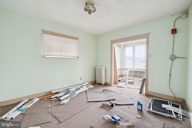 spare room with a textured ceiling and radiator