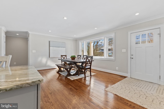 dining area featuring ornamental molding and light hardwood / wood-style flooring