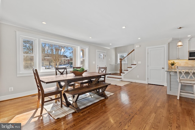 dining space featuring light hardwood / wood-style floors and crown molding