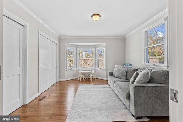 living room with crown molding, wood-type flooring, and plenty of natural light