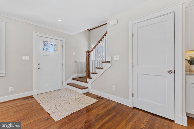 foyer featuring ornamental molding and dark hardwood / wood-style floors