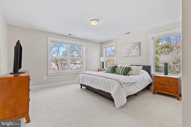 bedroom with light carpet and multiple windows