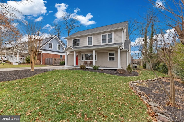 view of front property featuring a front yard, a garage, and covered porch