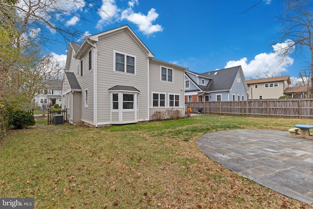 back of property featuring a yard, cooling unit, and a patio area