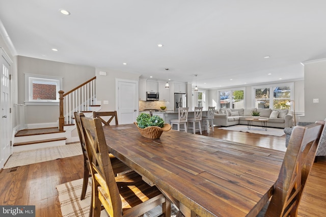 dining space featuring hardwood / wood-style floors and crown molding