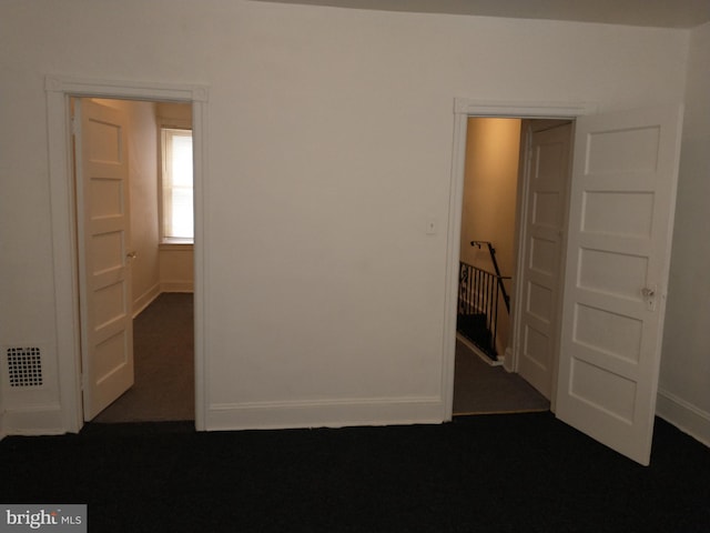 unfurnished bedroom with dark colored carpet