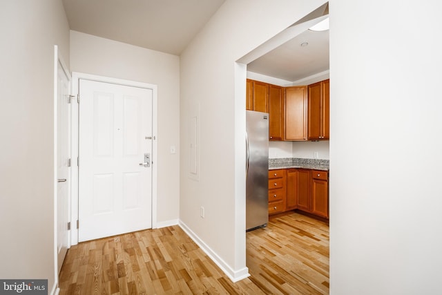 kitchen with stainless steel fridge and light wood-type flooring