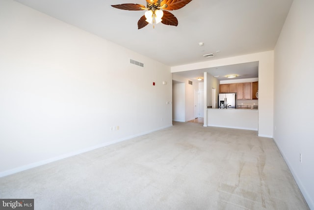 unfurnished living room with ceiling fan and light colored carpet