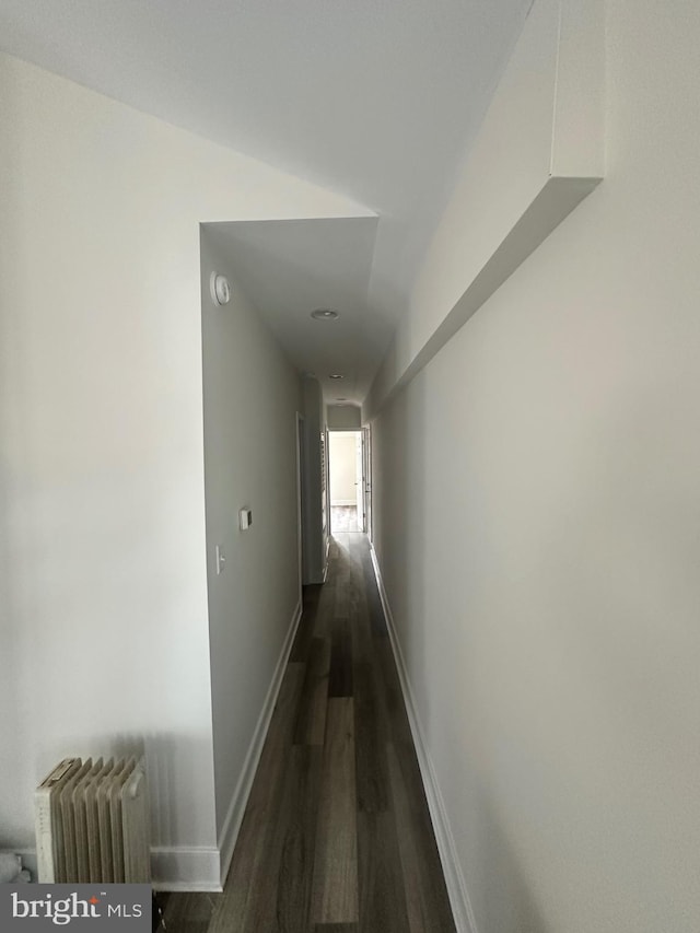 corridor with radiator heating unit and dark hardwood / wood-style floors