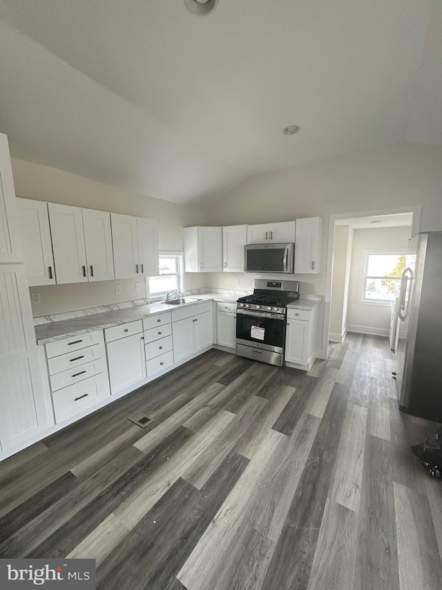 kitchen featuring white cabinetry, appliances with stainless steel finishes, sink, and a wealth of natural light