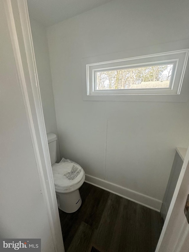 bathroom with hardwood / wood-style flooring and toilet