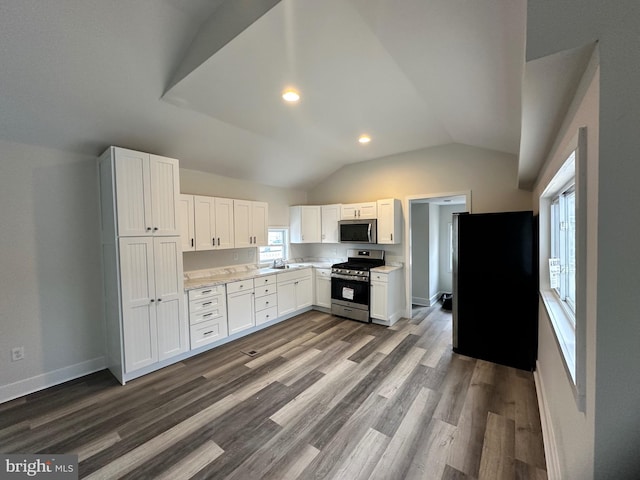 kitchen with white cabinetry, dark wood-type flooring, vaulted ceiling, and appliances with stainless steel finishes