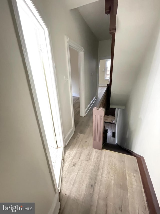 corridor with radiator and light hardwood / wood-style flooring