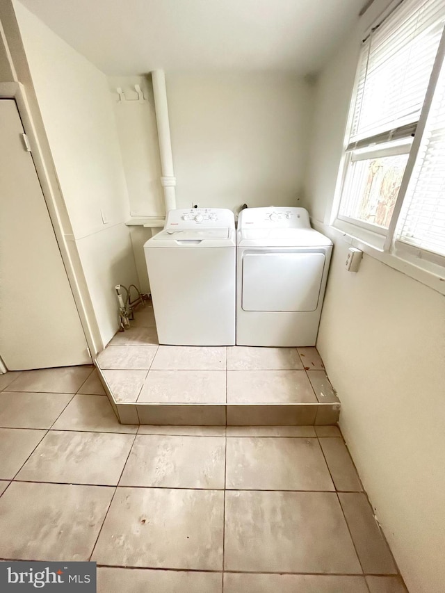 clothes washing area with light tile patterned floors and washing machine and clothes dryer