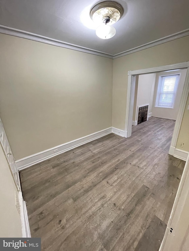 unfurnished room with wood-type flooring and crown molding