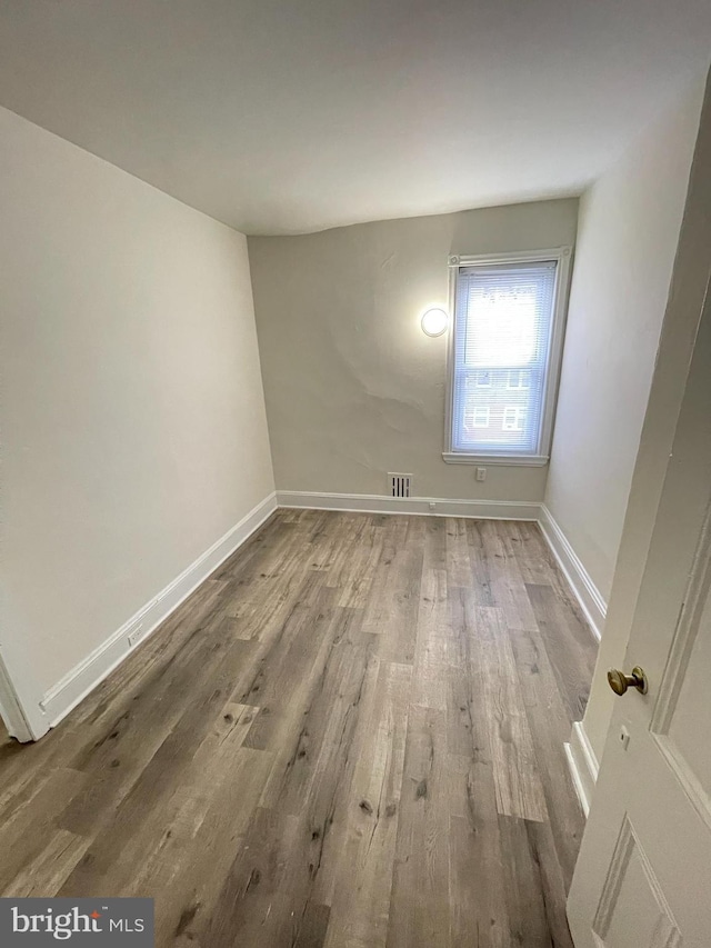 unfurnished room with wood-type flooring