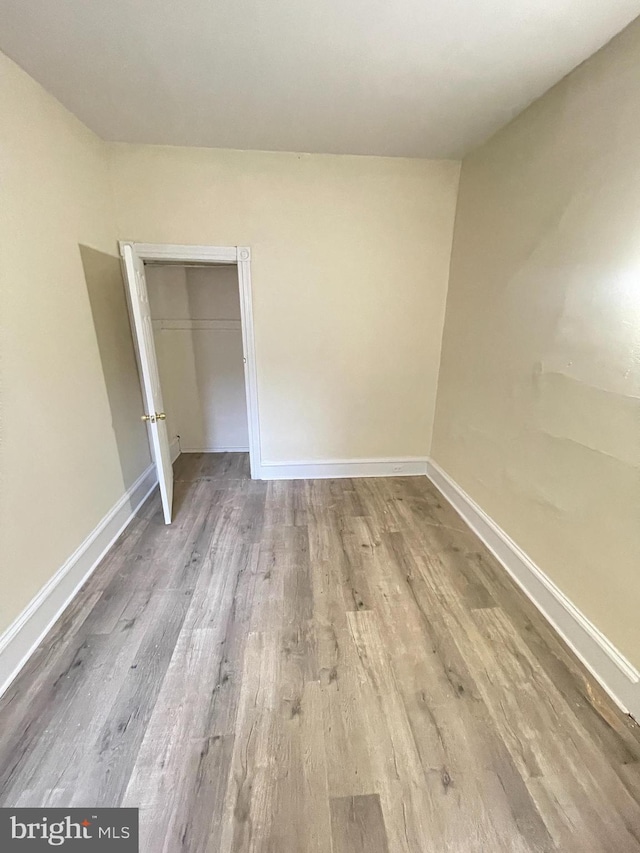 unfurnished bedroom featuring hardwood / wood-style floors and a closet