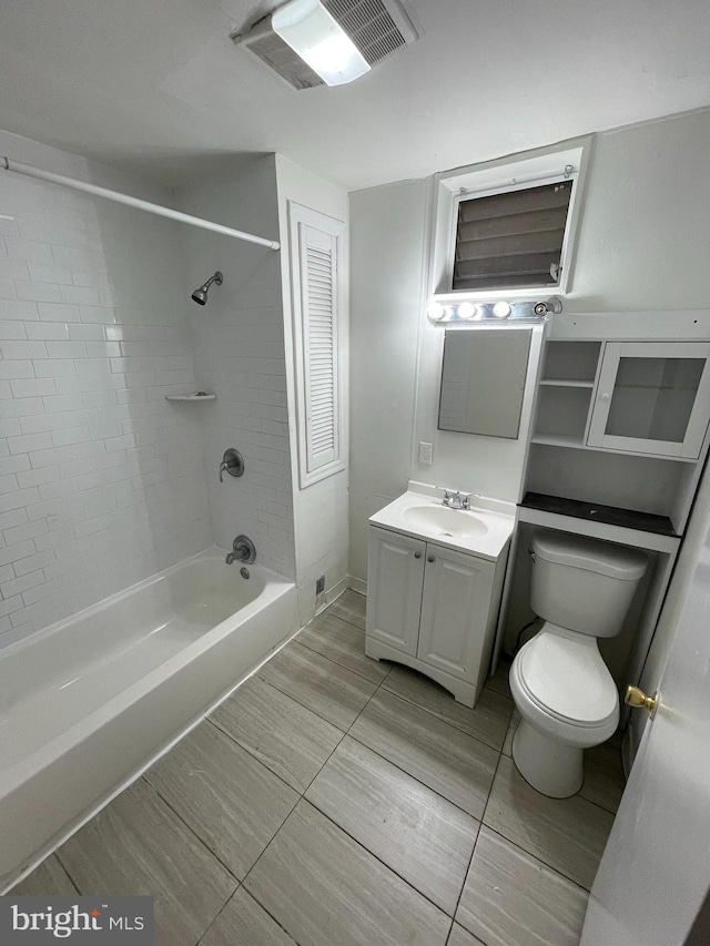 full bathroom featuring vanity, tiled shower / bath combo, and toilet