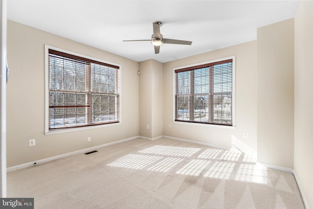 carpeted spare room featuring ceiling fan