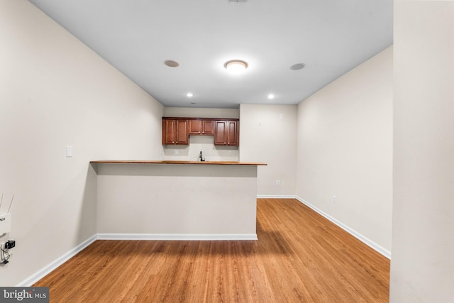 kitchen featuring sink, wood-type flooring, and kitchen peninsula