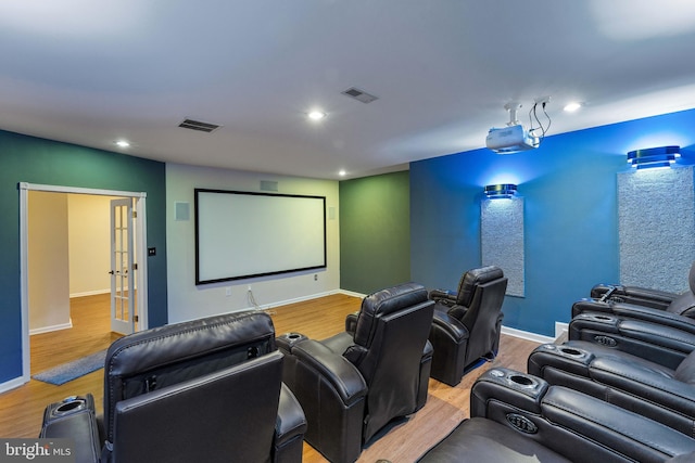 home theater featuring light wood-type flooring and french doors