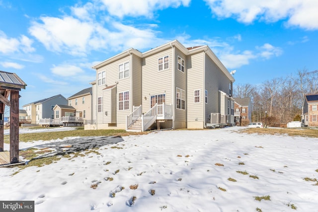 view of snow covered rear of property