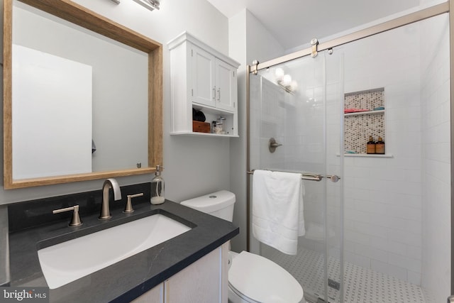 bathroom with toilet, walk in shower, and vanity