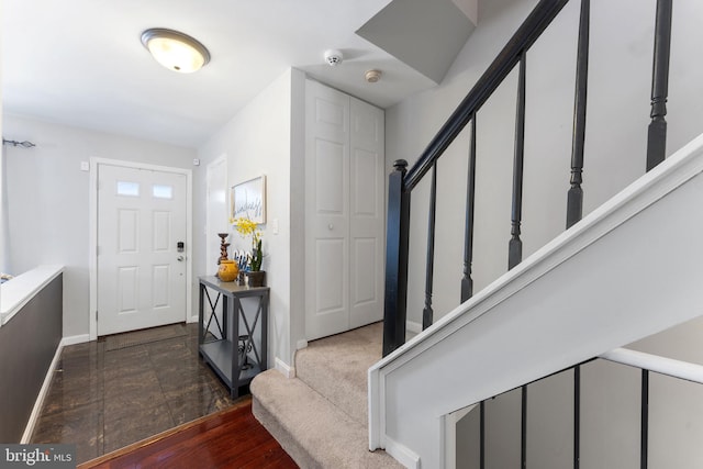 entrance foyer with dark carpet