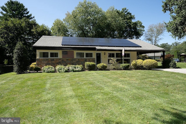 ranch-style home featuring solar panels and a front lawn