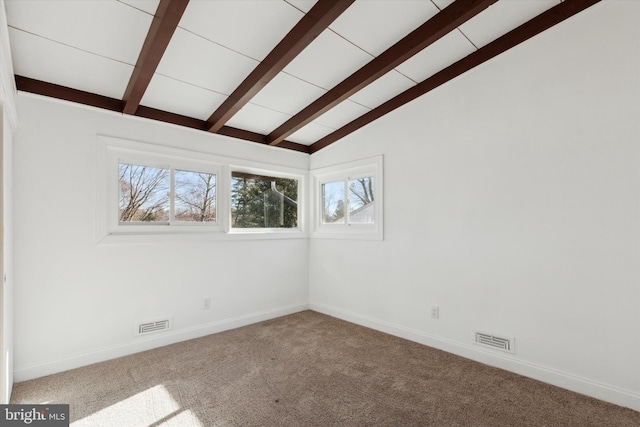 empty room with carpet flooring and vaulted ceiling with beams