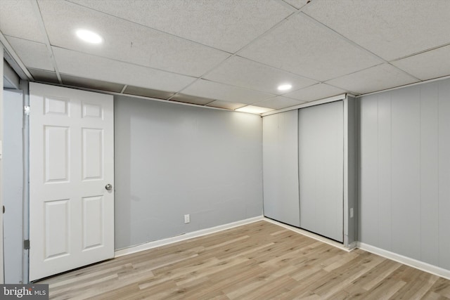 basement with light hardwood / wood-style floors and a drop ceiling