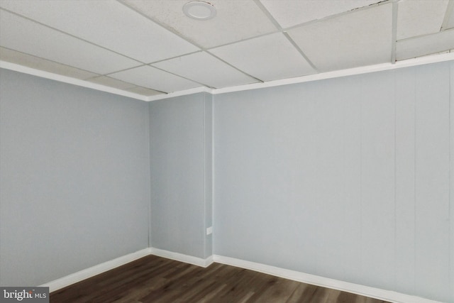 spare room featuring a paneled ceiling and dark hardwood / wood-style floors