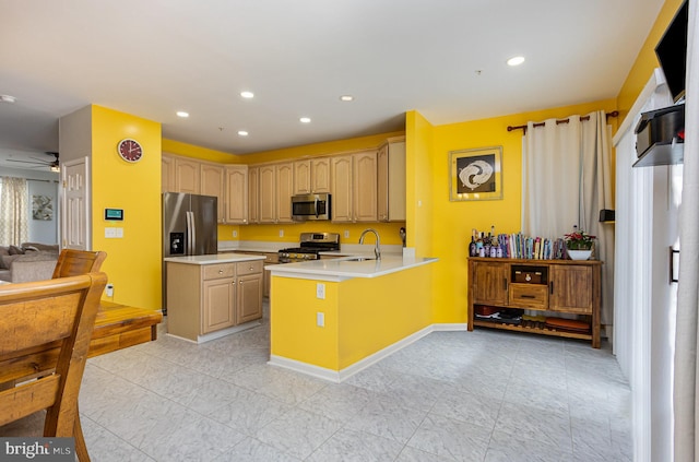 kitchen with appliances with stainless steel finishes, light brown cabinetry, sink, kitchen peninsula, and ceiling fan