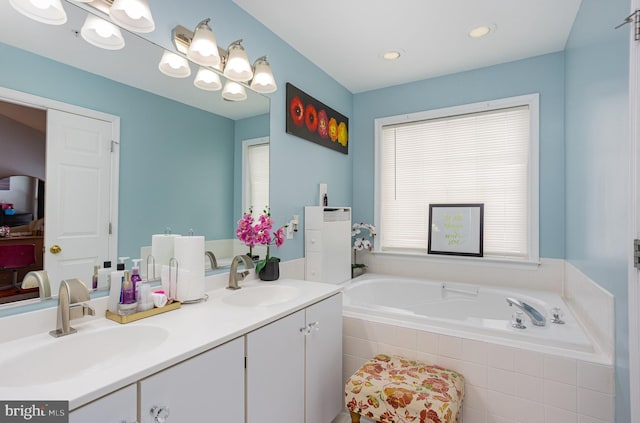 bathroom featuring vanity and tiled tub