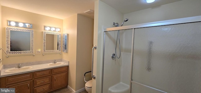 bathroom featuring toilet, a shower with door, and vanity