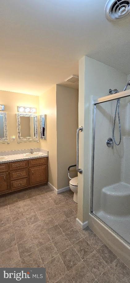 bathroom featuring vanity, toilet, and walk in shower