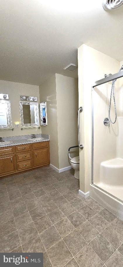 bathroom with vanity, toilet, and an enclosed shower