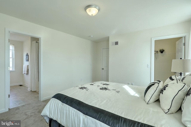 carpeted bedroom with a walk in closet and a closet