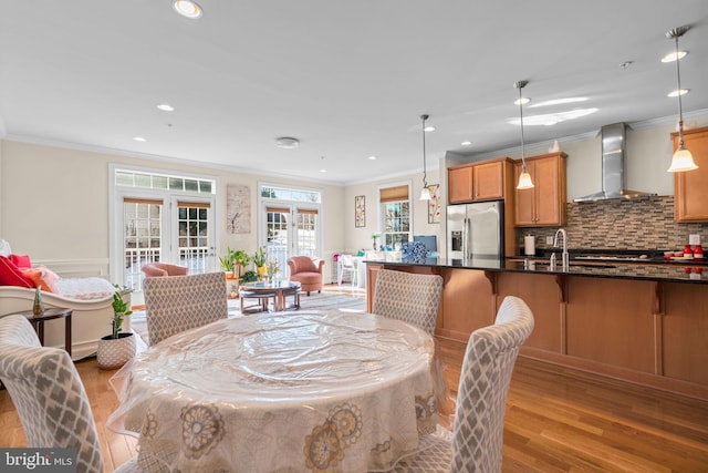 dining area with light hardwood / wood-style flooring and crown molding