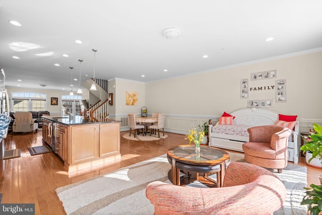 living room featuring crown molding, sink, and light hardwood / wood-style flooring