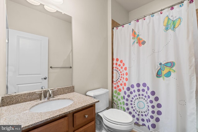 bathroom featuring vanity, toilet, and walk in shower